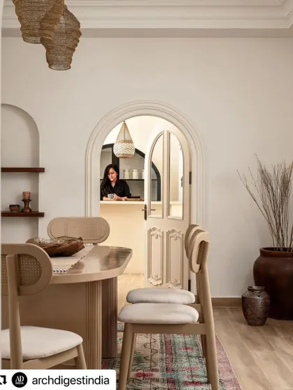 A look from the dining area into the bar, as seen in Architectural Digest. This image captures the seamless flow between spaces, unified by arched doorways and a consistent, warm aesthetic that encourages entertaining.