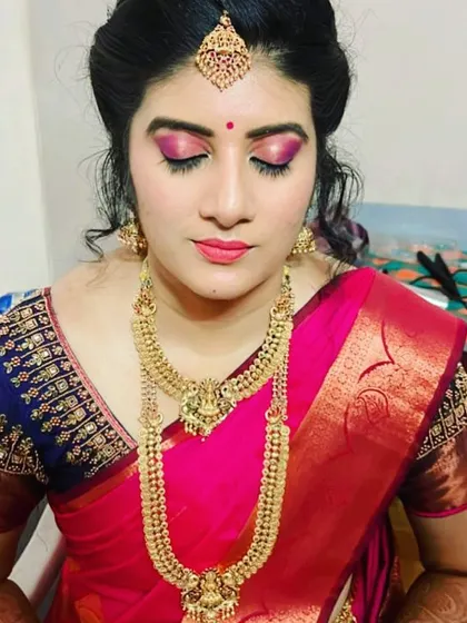 This image showcases a bold pink eyeshadow look on a beautiful bride. The color choice is designed to complement her pink Kanjivaram saree and gold jewellery, creating a striking and memorable appearance.