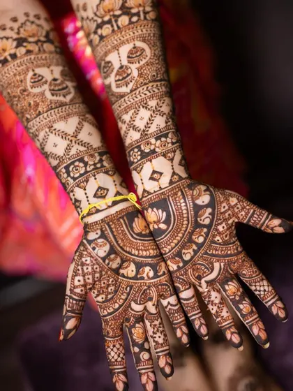 A close-up of the palms, featuring semi-circular mandalas with lotus and elephant details.