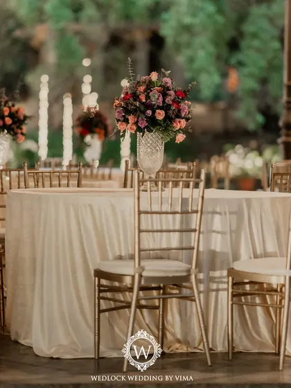 A simple yet elegant reception setup with soft lantern lighting and delicate drapes on the gazebo. The lush purple-themed florals and romantic centerpieces tied the whole look together.