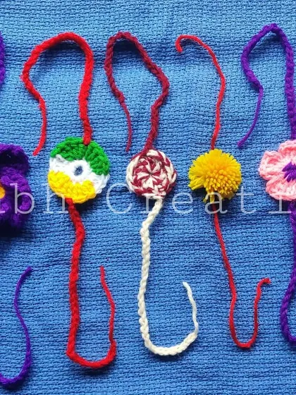 Another assortment of colorful crochet rakhis, featuring different flower and pompom styles.