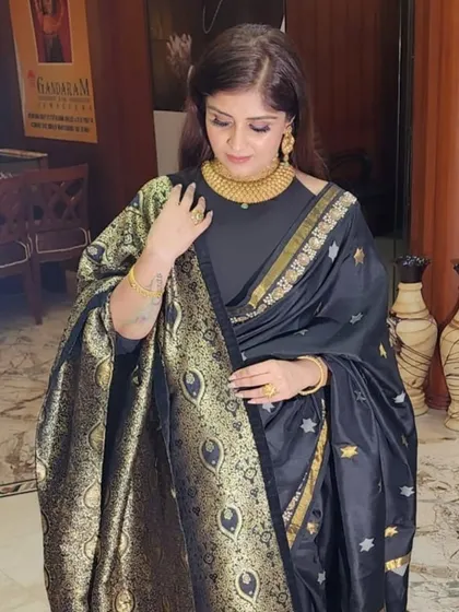 A classic black Banarasi silk saree with intricate gold weaving. This is timeless elegance, perfect for any grand occasion.