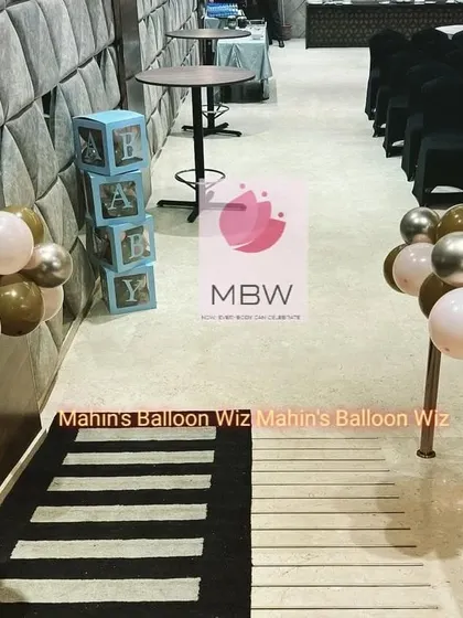 A detail shot showing the aisle decor, including "BABY" blocks and small balloon clusters that continue the theme throughout the venue.