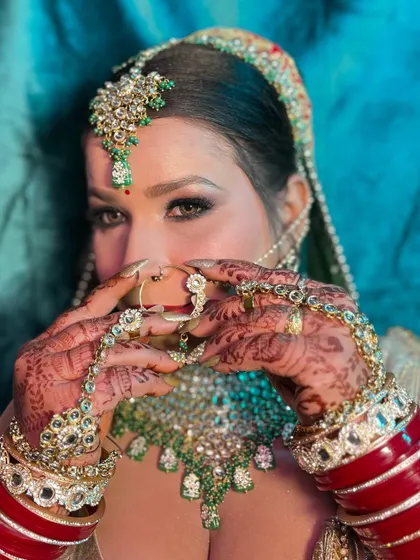 The beauty is in the details. This shot focuses on the intricate henna, the stunning rings, and the traditional nath, all part of the complete bridal look.