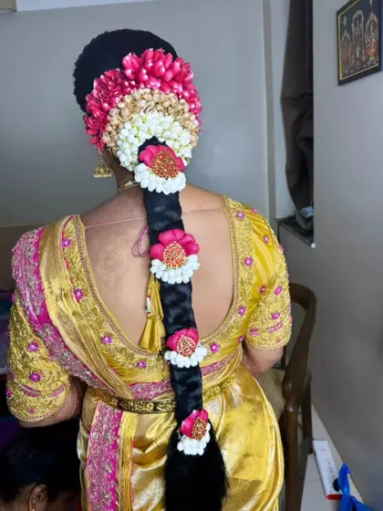A vibrant and colorful floral braid using a mix of pink, white, and artificial flowers for a festive look.