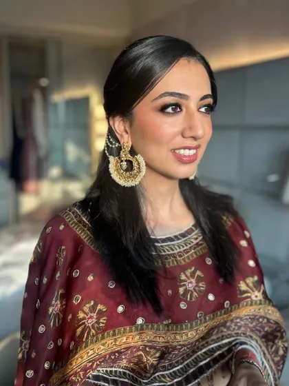 A three-quarter profile shot showcasing the complete look, including the simple yet elegant hairstyle that keeps the focus on the makeup and traditional jewelry.
