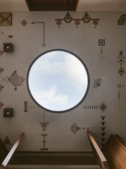 Looking up from the base of the Oonjal, the ceiling of the courtyard reveals a large circular skylight framed by a beautiful mosaic of Kolam-inspired patterns.