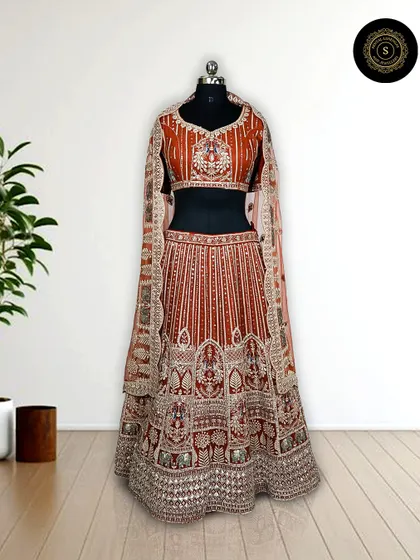 Another angle of the stunning rust-orange lehenga, showcasing the detailed craftsmanship on the skirt and blouse.