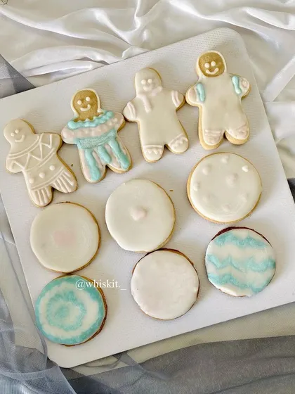 An assortment of my custom iced cookies, including gingerbread men and other festive shapes.