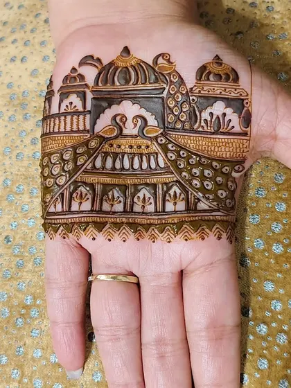A trial mehandi design for the palm. This pattern features a beautiful palace scene with peacocks, giving a glimpse of our artistic capabilities.