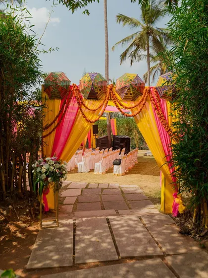 The vibrant Mehendi entrance, framed by bamboo trees, creates a beautiful transition from the natural environment to the colorful celebration within.