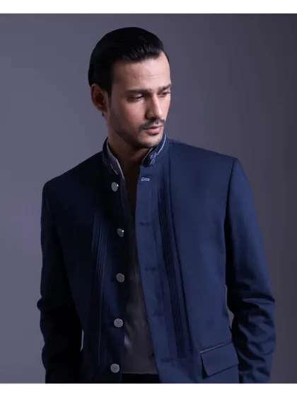 True elegance is crafted, not bought. This image of a navy blue suit with unique button detailing redefines your wardrobe with a bespoke piece that perfectly captures your refined style.