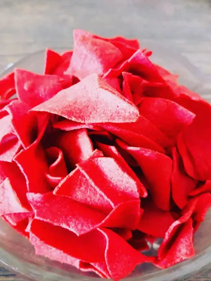 Bright red roasted beetroot chips, a colourful and nutritious snack that is naturally sweet and crispy.