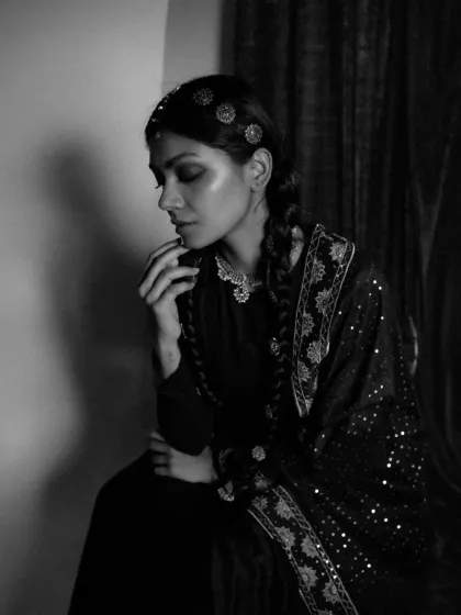 A pensive, black and white profile from the 'Amodini' series. This shot focuses on the delicate hair accessories and the quiet emotion conveyed through the model's posture and expression.