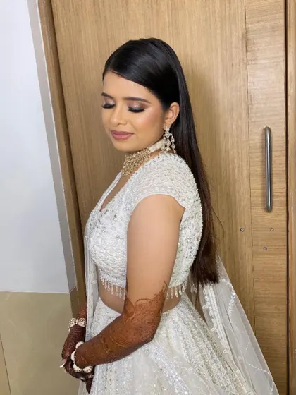 For this bride's sangeet, we chose a classic smokey eye and a sleek, modern hairstyle. The makeup perfectly complements her stunning white Seema Gujral lehenga.