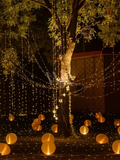 A magical outdoor lighting installation. I used strings of fairy lights hanging from trees and scattered glowing orbs on the ground to create an enchanted forest feel.