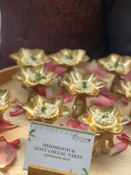 Elegant mushroom and goat cheese tarts served in beautiful golden lotus-shaped cups, finished with a dusting of parmesan.