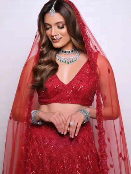 The full look, with the sheer red dupatta framing the bride's face, showcases a modern and sophisticated bridal style.