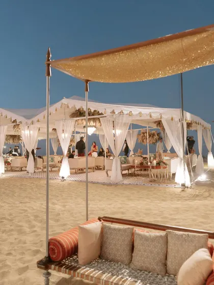 An evening view of the luxurious tents we set up for the desert party. With elegant draping and warm lighting, we created a comfortable and chic oasis for guests to dine and celebrate.