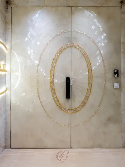 The play of light on the Selenite stone gives this entrance a natural luster. The custom-designed, backlit nameplate adds a personalized touch, making the entryway feel both grand and welcoming.