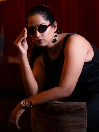 A seated portrait from the same shoot, conveying a cool and relaxed attitude. The lighting is carefully controlled to create a moody yet polished look.