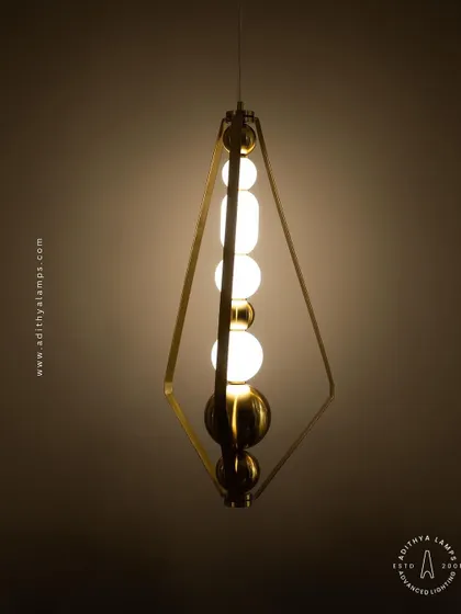 This elegant pendant is framed by a triangular gold structure, enclosing a string of white and gold beads. It's a sophisticated and modern piece that adds a touch of jewelry-like decoration to your space.