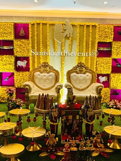 A unique setup for a joint ceremony, featuring two thrones and a backdrop with traditional motifs. The empty plates are arranged in front, ready for the rituals.