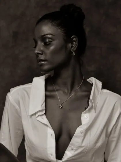 A soft and pensive black and white portrait. The lighting is gentle and creates a beautiful, classic mood.