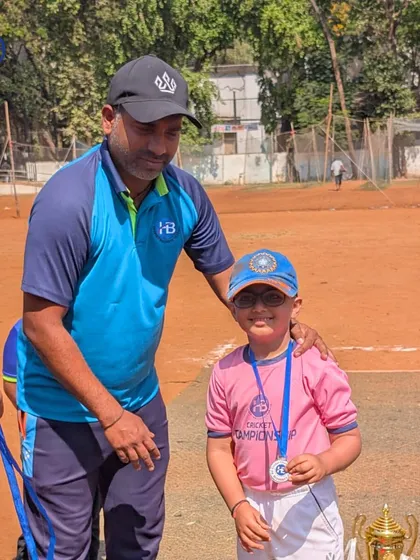 A coach proudly presents a medal to one of our young champions. We believe in recognizing individual effort and celebrating every player's contribution to the team's success.