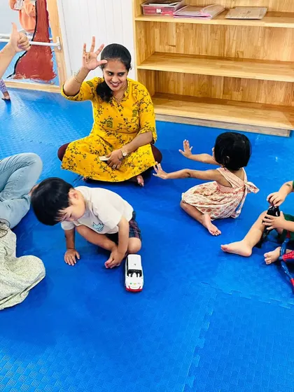 A fun number game in action! Children use their bodies and toys to learn counting during a group activity on the floor.