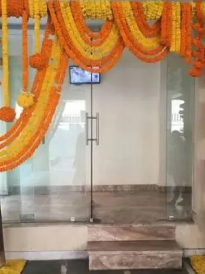 A simple yet elegant entrance decoration using marigold garlands to create an arch over a glass door.