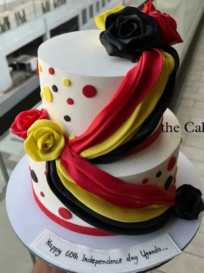 Another angle of the two-tier cake for Uganda's 60th Independence Day, showing the fondant flag-colored drapes and roses.