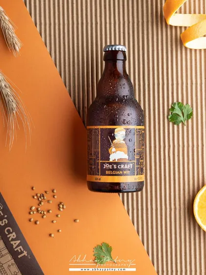 A creative product flat lay for a beer bottle. I used corrugated paper and wheat stalks to add texture and hint at the ingredients, giving the shot an earthy, craft feel.
