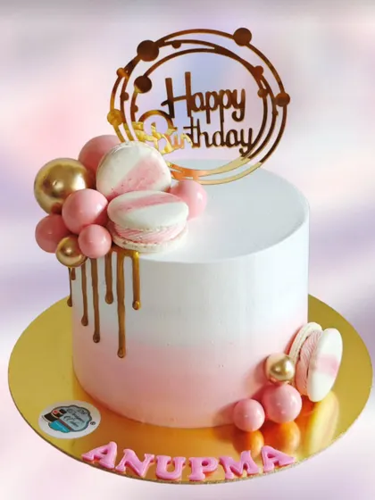 A similar design to one of my popular cakes, this one was customized for Anupma's birthday. It features a pink ombre effect, a golden drip, and is decorated with macarons and chocolate balls.