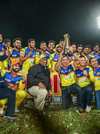 The entire Mysuru Warriors team and support staff celebrating with the Maharaja T20 trophy. Victories like these are a collective effort.