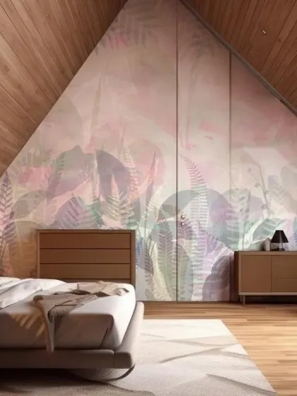 An attic bedroom is transformed into a cozy retreat with a pastel-colored leaf mural applied to the angled wall and wardrobe doors, creating a seamless, immersive feel.