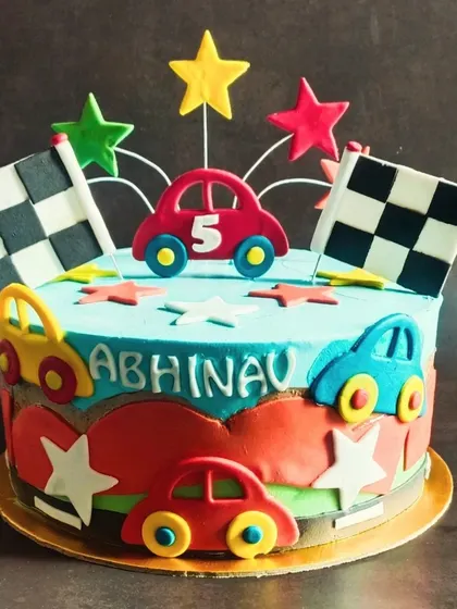 A vibrant car-themed cake with racing flags and stars, perfect for a high-energy 5th birthday party.