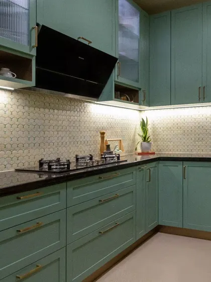 The tranquil green kitchen, designed to maximize storage and functionality. A beautiful floral backsplash and classic fluted glass elevate the overall look with a touch of sophistication.