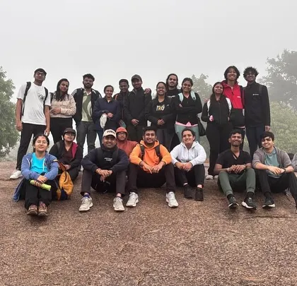 A group photo on a large rock, surrounded by fog. These are the moments that make monsoon treks magical.