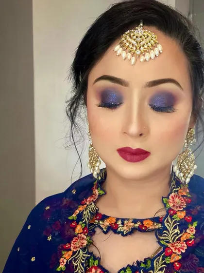 A stunning blue smokey eye paired with a bold red lip. This is a classic combination for a glamorous evening event, perfect for Eid or any festive celebration.