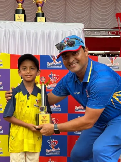 A coach shares a happy moment with a U-10 award winner, showcasing the supportive and encouraging atmosphere at our academy.