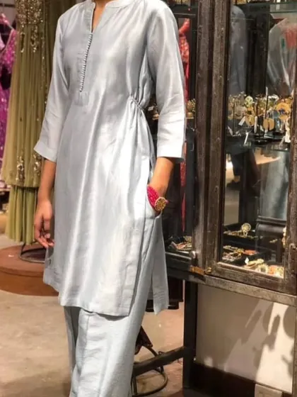 A chic and modern light blue silk co-ord set. The kurta has a stylish side-tie detail, offering a contemporary twist on a classic silhouette.