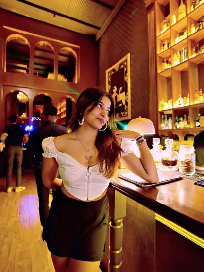 A guest posing by the well-stocked bar at 10SpeakEasy.