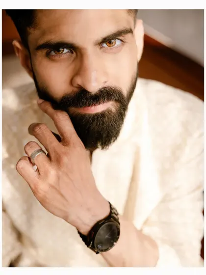 A striking close-up portrait of the groom, highlighting his sharp features and intense gaze.