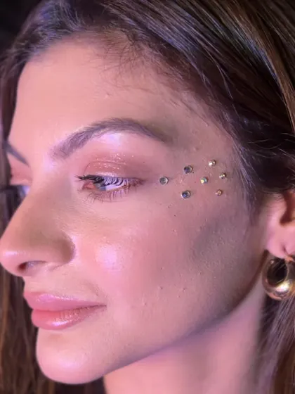A scattered placement of small rhinestones under the eye for a subtle sparkle. This is a very popular and trendy look that works for any party.