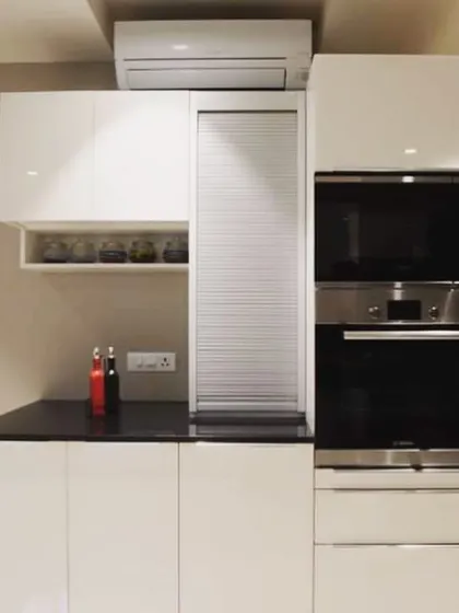 This shot highlights the appliance garage with a rolling shutter, a practical feature for hiding small appliances and keeping the countertop clutter-free. The built-in AC unit above shows our ability to work around existing fixtures.