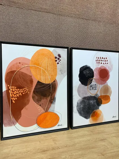 This pair of abstract canvases, framed in dark floater frames, adds a touch of modern sophistication to any room.