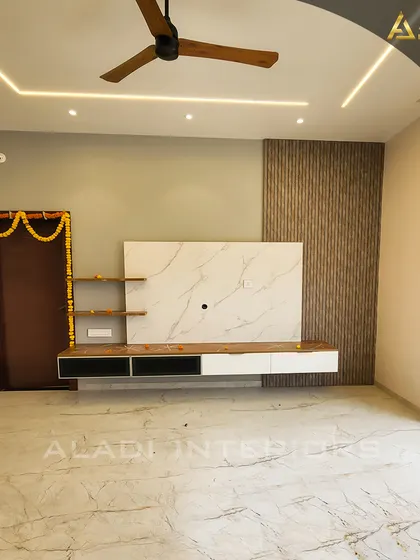 A minimalist TV unit against a backdrop of white marble and wood fluting. The clean lines and uncluttered design make this living room feel spacious and serene.