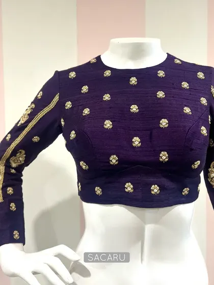 Understated elegance defines this intricately hand-embroidered blouse. The full sleeves feature paisley motifs, while the body is dotted with small butis.
