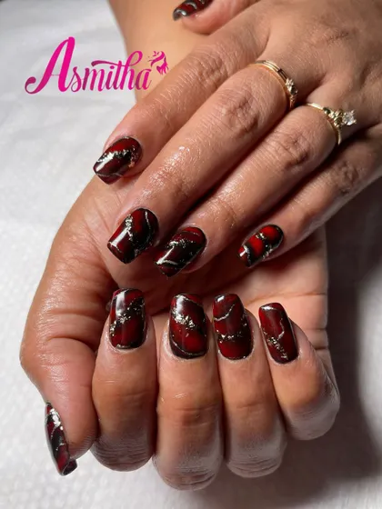 Another angle of our popular red, black, and gold marble nail extensions. This view highlights the depth and dimension of the hand-painted design.